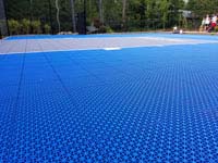 Closeup of Versacourt tile surface of blue and gray residential basketball court in Easton, MA.