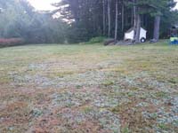Expanse of lawn that will become a basketball court featuring Celtics logo, with fire pit, patio, and light for night play, in Londonderry, NH.