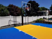 Royal blue and yellow residential basketball court in Stoneham, MA.