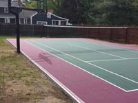Backyard basketball and tennis multiple sport court in Sudbury, MA, surfaced with low impact, high performance burgundy and slate green outdoor Versacourt tiles.