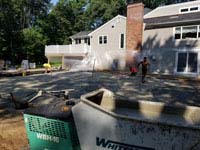 Installing concrete base for graphite and orange residential basketball court replacing a dead pool in Walpole, MA.