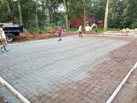 Preparing form to receive concrete for base for graphite and orange residential basketball court replacing a dead pool in Walpole, MA.