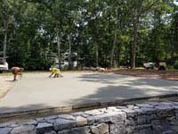 Preparing cement base for graphite and orange residential basketball court replacing a dead pool in Walpole, MA.