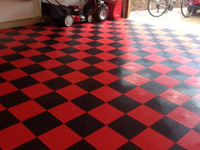 Example picture of an installation of specialty indoor tile floor in a garage, in alternating red and black.